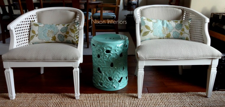 painted white reupholstered french cane barrel chirs in neutral material modern styling with ceramic asian inspired stool