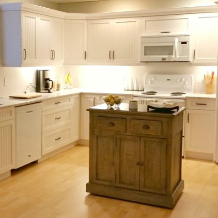 updated white kitchen with rubbed bronze handles and weathered kitchen island